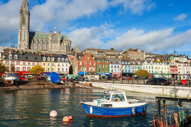 Bunte Hafenstadt in Irland mit Boot im Vordergrund